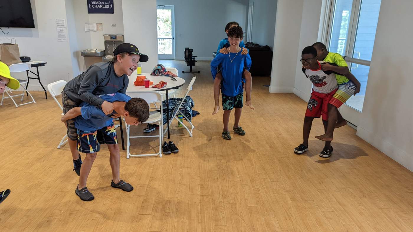 A group of children carrying other children piggyback