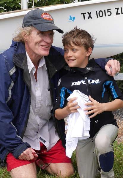 Adult with young boy next to boat